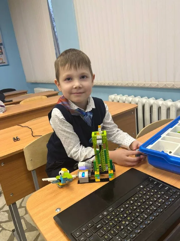 Ребёнок собирает LEGO-робота на занятии в Роббурге